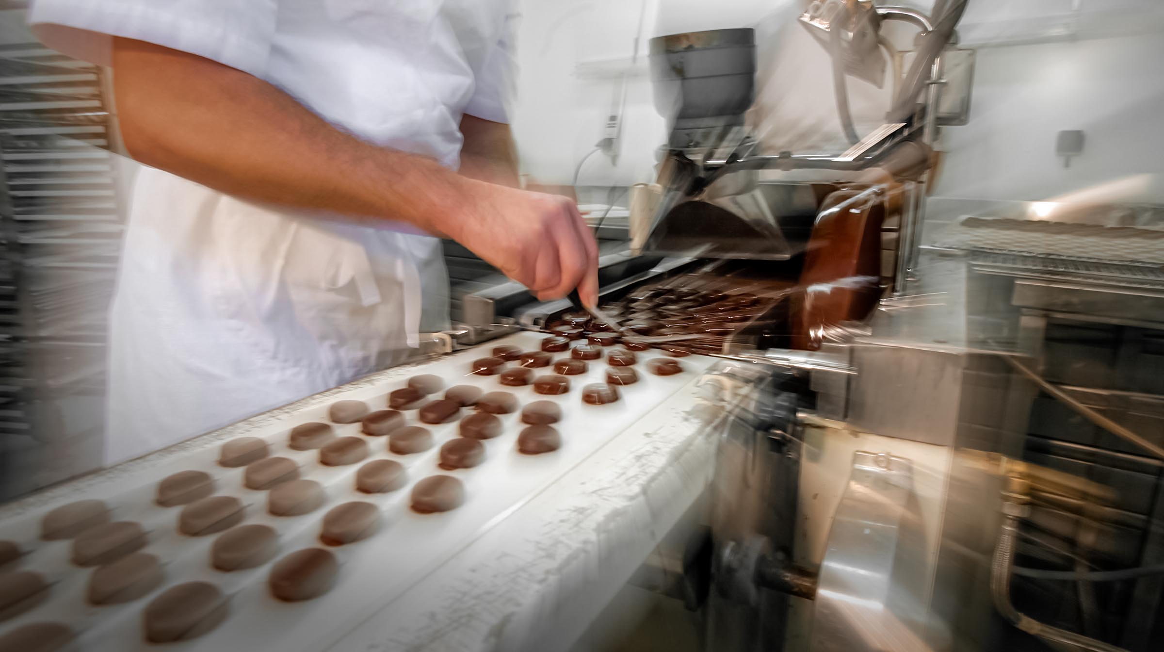 Artisan et maître chocolatier disposant des chocolats sur une grille